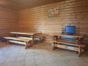 a room with a wooden wall with a table and benches at Kļūda 2 in Biksinīki