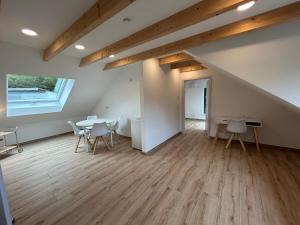an attic room with tables and chairs and a window at MainSpessartBlick in Lohr am Main