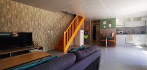 a living room with a couch and a kitchen at Chez Nova in Chaudenay