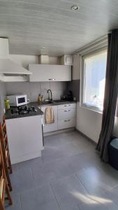 a small kitchen with white cabinets and a window at Chez Nova in Chaudenay