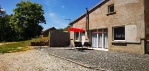 a building with a red umbrella next to a building at Chez Nova in Chaudenay