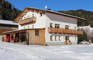 a large building with a balcony in the snow at VALRUNZHOF direkt am SEILBAHNCENTER in Nauders