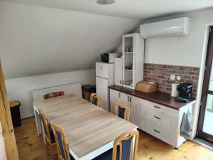 a kitchen with a wooden table and chairs and a counter at Apartment 2 in Hrabušice