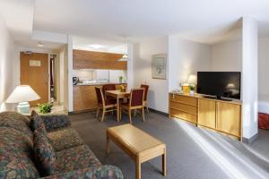 a living room with a couch and a dining room at Cartier Place Suite Hotel in Ottawa