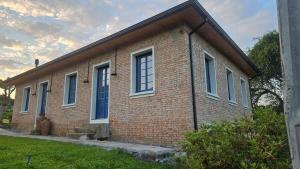 a brick building with blue windows on the side of it at Casa 80 in Monte Belo