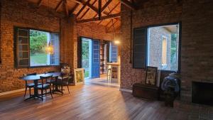 a room with a table and chairs and a brick wall at Casa 80 in Monte Belo +12 photos
