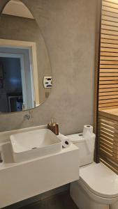 a bathroom with a sink and a toilet and a mirror at Casa 80 in Monte Belo