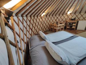 a bedroom in a yurt with a bed and a table at Jurte Falkenauge Schweiz in Schönengrund