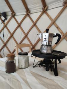 a table with a coffee pot on a burner at Jurte Falkenauge Schweiz in Schönengrund