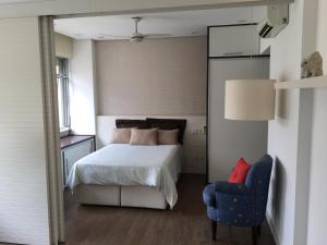 a bedroom with a bed and a blue chair at Apartamento em Copacabana in Rio de Janeiro