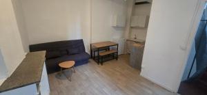 a small living room with a couch and a table at Olti in Avignon