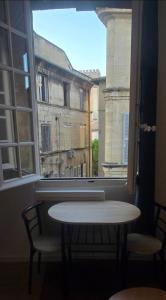 a table and chairs in front of a window at Olti in Avignon