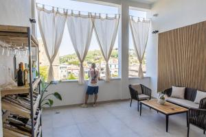 a young child standing in a living room looking out the window at Barrio La Suite del Borgo Bacoli in Bacoli