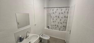 a white bathroom with a sink and a toilet at Olti in Avignon