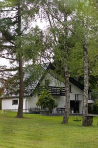 a white building with trees in front of it at Leśne Chwile in Osiek
