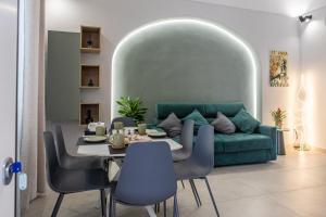 a dining room with a green couch and a table at Barrio La Suite del Borgo Bacoli in Bacoli
