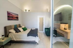 a bedroom with a bed and a green couch at Barrio La Suite del Borgo Bacoli in Bacoli