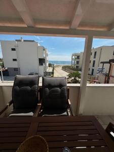 a balcony with two chairs and a view of the beach at Villa LIR in Vir