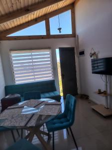 a living room with a table and a couch at Cabaña Litueche in Los Manantiales