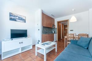 a living room with a blue couch and a table at Apartaments VM Molleres in Soldeu