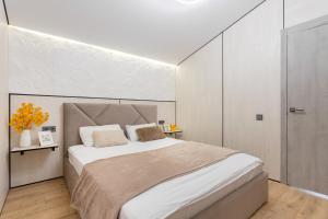 a bedroom with a large bed with white walls at Басейн Чан с Джакузи Дом Посуточно Осокорки Киев in Kyiv