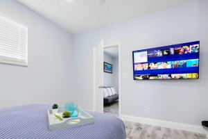 a bedroom with a bed and a flat screen tv on a wall at Mayas Blue Lagoon Luxury Suite #2 in Fort Lauderdale