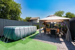 a patio with an umbrella and a table and chairs at Басейн Чан с Джакузи Дом Посуточно Осокорки Киев in Kyiv