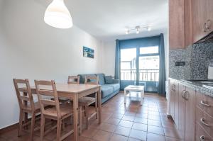 a kitchen and dining room with a table and a couch at Apartaments VM Molleres in Soldeu