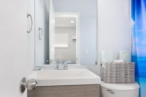 a bathroom with a sink and a toilet with a mirror at Mayas Blue Lagoon Luxury Suite #2 in Fort Lauderdale +30 photos