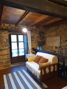 a living room with a couch and a window at Vega in Muñás
