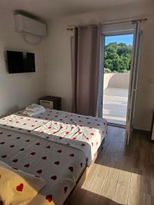 a bedroom with two beds and a sliding glass door at Apartmani Zara in Pečurice