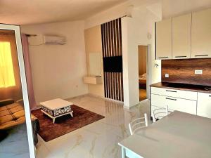 a kitchen with white cabinets and a table in a room at Apartmani Zara in Pečurice