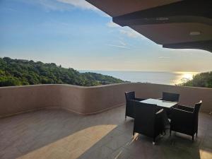 a balcony with a table and chairs and the ocean at Apartmani Zara in Pečurice