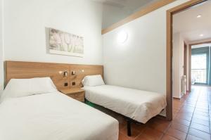 a hotel room with two beds and a mirror at Apartaments VM Molleres in Soldeu