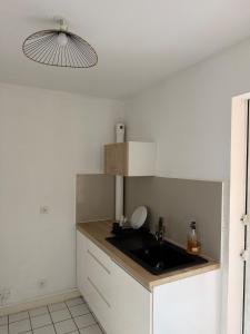 a small kitchen with a sink and a light at Appartement Kazalya in Sainte-Rose