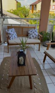 a patio with a wooden table and a bench at Appartement Kazalya in Sainte-Rose