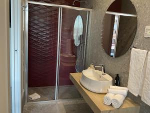 a bathroom with a sink and a shower with a mirror at VILLA ACTEA in Vasto