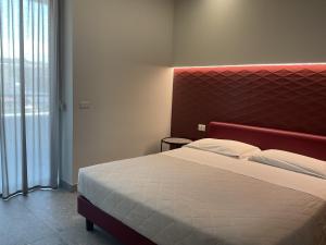 a bedroom with a large bed with a red headboard at VILLA ACTEA in Vasto +50 photos