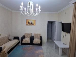 a living room with a couch and a chandelier at 2-Room Modern House in Naxçıvan