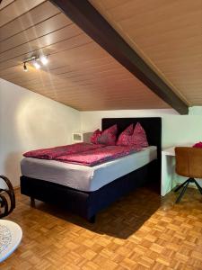 a bedroom with a bed with red pillows on it at Amselhof Kördorf in Kördorf