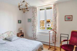 a bedroom with a bed and a window and a chair at Chez Marie in Dunkerque