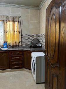 a kitchen with a washing machine in a kitchen at جرش in Dayr al Līyāt