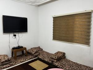 a living room with a flat screen tv on the wall at جرش in Dayr al Līyāt