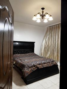 a bedroom with a bed and a chandelier at جرش in Dayr al Līyāt