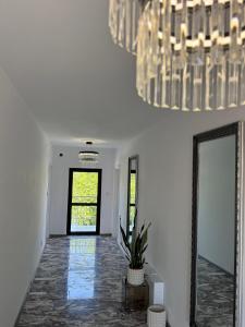 a hallway with a mirror and a chandelier at Millennium Guest House in Kŭrdzhali