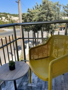 a yellow chair and a table on a balcony at Millennium Guest House in Kŭrdzhali