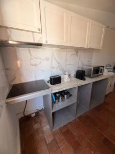 a kitchen with white cabinets and a counter top at Maria's in Faro
