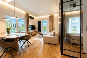 a living room with a dining table and a bedroom at Porto Marina - widok na jezioro z każdego z 3 pokoi, lux, garaż, klima in Iława +21 photos