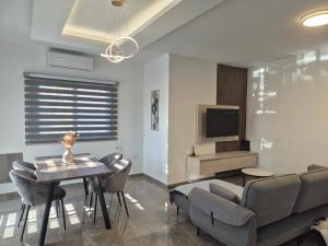 a living room with a couch and a table and a tv at AK Appartment in Kato Pyrgos
