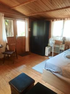a bedroom with a bed and a chair and windows at Chalet au centre de Nice in Nice